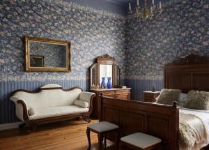 a bedroom with a bed and a chair and a mirror at Pałac Przybyszewo in Przybyszewo