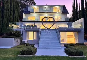 a house with a heart on the front of it at Bayview Luxe Retreat in Tascott +7 photos