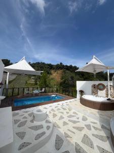 a villa with a swimming pool and two umbrellas at Glamping Grand Mazaya Private Pool in Bandung