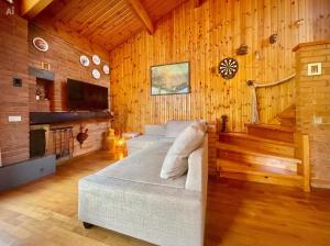 a bedroom with a bed in a room with wooden walls at Chalet Costa Rotian in Commezzadura
