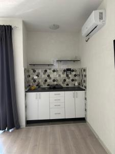 a kitchen with white cabinets and a counter top at Kale Apartments Trpejca SUP and bikes included in Ohrid