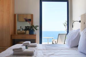 a bedroom with a bed with towels on it at OdeSea Aegean Studios in Plomari