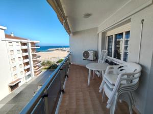 a balcony with a table and chairs and the beach at Apartaments Lamoga - Boabi in Torredembarra