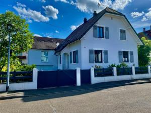a white house with a blue fence at Le nid d'Eve - studio cosy près de Strasbourg avec piscine in Illkirch-Graffenstaden