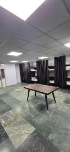 a wooden table in an empty room with curtains at Chandra Dormitory in Varanasi