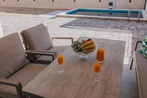 a table with a bowl of fruit and two glasses of orange juice at Villa Anida in Ulcinj