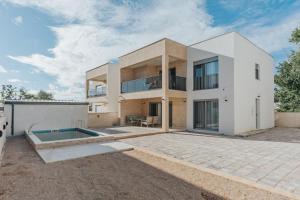 a large white house with a pool in front of it at Villa Anida in Ulcinj