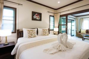 a bedroom with a large white bed with a towel on it at Bang Po Hut in Ban Bang Po