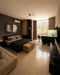 a bedroom with a bed and a couch and a desk at Hotel Kamomil in Durrës