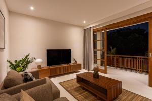 a living room with a couch and a television at Villa Pura Bali in Canggu