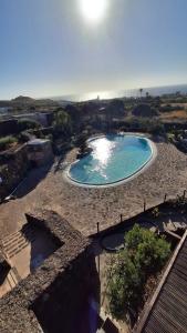 an overhead view of a swimming pool with the ocean in the background at Dammuso Kazen Jezabel in Pantelleria