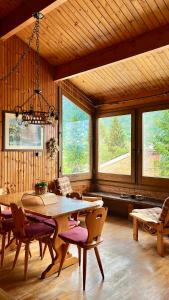 a dining room with a table and chairs and windows at Chalet Costa Rotian in Commezzadura