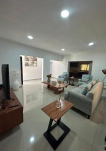a living room with a couch and a tv at JAYNIEL Apartments in Lusaka