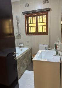 a bathroom with a tub and a sink at JAYNIEL Apartments in Lusaka +4 photos