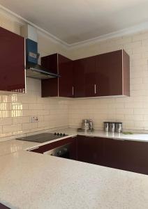 a kitchen with brown cabinets and a counter top at JAYNIEL Apartments in Lusaka