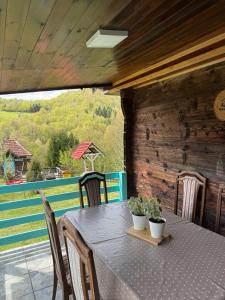 a table and chairs on a porch with a view at Etno selo Raković in Ivanjica