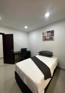 a bedroom with a bed and a desk in it at JAYNIEL Apartments in Lusaka