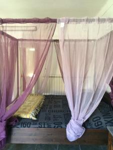 1 cama con cortinas moradas en una habitación en L'arco di corso Garibaldi 202 en Soveria Mannelli