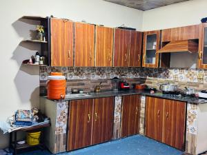 a kitchen with wooden cabinets in a room at Valley View Homestay in Bīrgal +7 photos