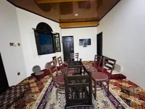 a dining room with a table and chairs and a tv at Valley View Homestay in Bīrgal