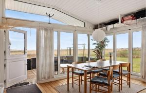 a dining room with a table and chairs and windows at 3 Bedroom Cozy Home In Haderslev in Haderslev