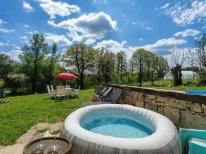 a hot tub in a backyard with a table and chairs at Bachvarov house Бъчваровата къща in Palitsi