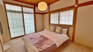 a bedroom with a large bed with four windows at Tabinoteitaku 和-WA- in Sendai