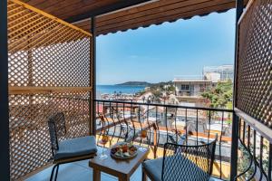 a balcony with chairs and a table and a view of the ocean at Çınar Butik Hotel in Kaş