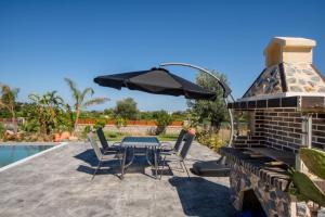 a patio with a table and chairs and an umbrella at George's Paradise in Afantou