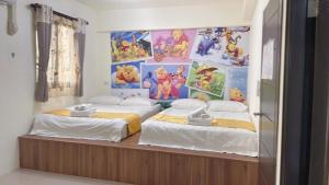 two beds in a room with posters on the wall at Round toot in Jinning