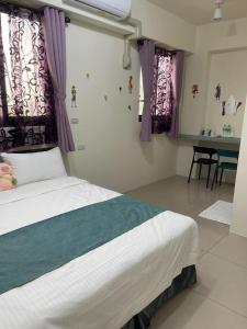 a bedroom with a bed with purple curtains and a table at Round toot in Jinning