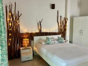 a bedroom with a large bed with lights on it at Papaya Hikkaduwa in Hikkaduwa