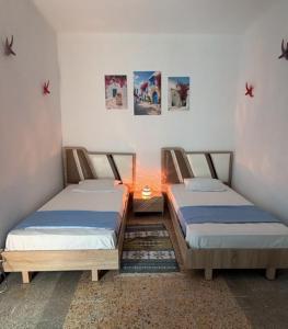 two beds in a room next to each other at Dar Hkaïem in Sousse