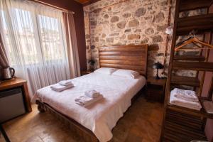 a bedroom with a bed with towels on it at Blue Boz Küçükköy in Ayvalık