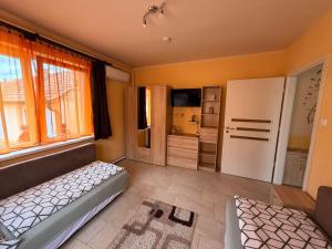 a bedroom with a bed and a large window at Adél Apartman in Sárvár
