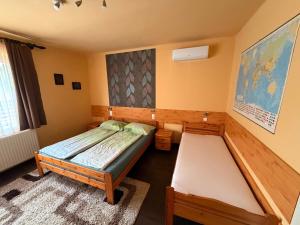 a bedroom with two beds and a rug at Adél Apartman in Sárvár