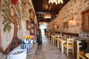 a restaurant with a row of tables and chairs at Blue Boz Küçükköy in Ayvalık