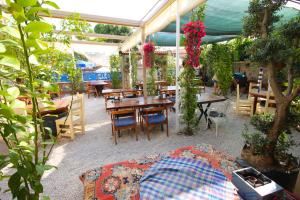 a patio with tables and chairs and plants at Blue Boz Küçükköy in Ayvalık