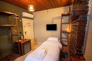 a hotel room with two beds and a tv at Blue Boz Küçükköy in Ayvalık
