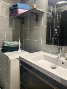 a bathroom with a sink and a mirror and towels at Le cocon du télésiège - Piscine chauffée - Métabief in Métabief