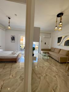 a living room with a couch and a table at Coral Blue By Infinity in Nea Kallikrateia