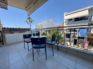 a balcony with a table and chairs on it at Coral Blue By Infinity in Nea Kallikrateia
