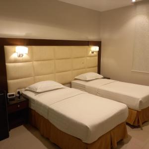 a hotel room with two beds and two lamps at شقق نزل التوت للشقق المخدومة in Al Kharj +15 photos