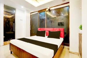 a bedroom with a large bed with a red headboard at Hotel O Kashish Residency in New Delhi