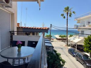 a balcony with a table and a view of the ocean at Coral Blue By Infinity in Nea Kallikrateia