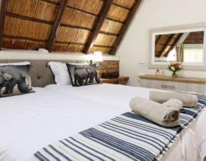 a bedroom with a large white bed with pillows at Selukwe Safari Lodge in Marloth Park