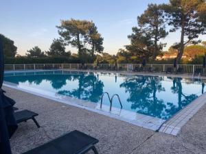 a swimming pool with a reflection in the water at Chiberta Ocean & Golf Suite in Anglet