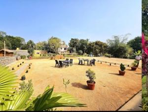 a yard with tables and chairs and potted plants at LEO DREAM HAMPi in New Hampi
