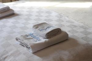 a folded towel on a bed with a checkerboard table at Blue Boz Küçükköy in Ayvalık +30 photos