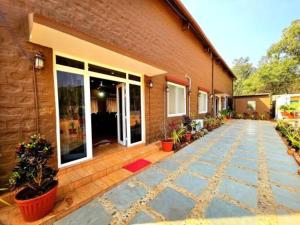 a brick building with potted plants in front of it at LEO DREAM HAMPi in New Hampi